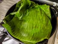 Daun pisang membaluti campuran ikan dan bahan tumis di dalam cast iron skillet Daun pisang membaluti campuran ikan dan bahan tumis di dalam cast iron skillet
