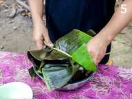 Mengikat bungkusan dengan pelepah daun pisang Mengikat bungkusan dengan pelepah daun pisang