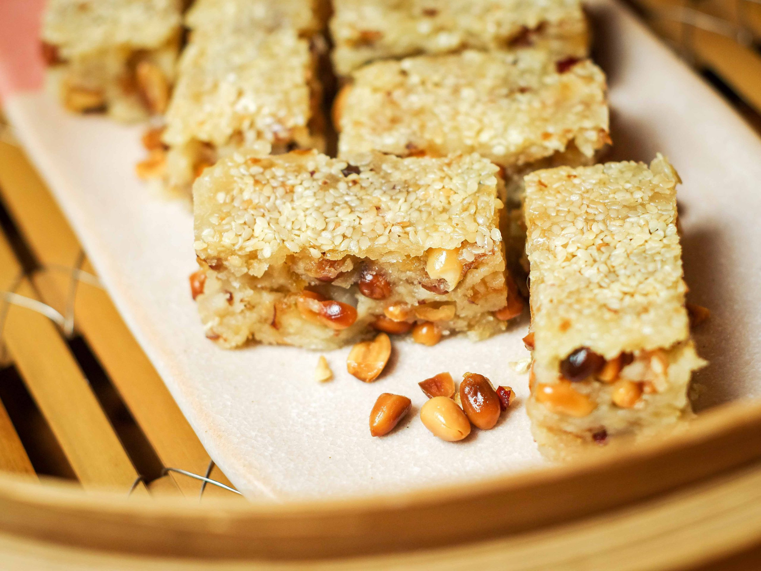 Rectangular pieces of manjiu gor are arranged on a pink plate, set inside a bamboo steamer.