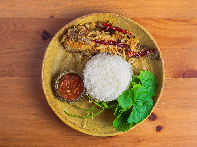 Sepinggan makanan dipamerkan di atas pinggan seramik di atas meja kayu. Di atas pinggan terdapat pekasam ikan haruan yang digoreng bersama cili dan bawang, daun pegaga, dan sambal belacan di dalam mangkuk kecil, mengelilingi nasi putih.