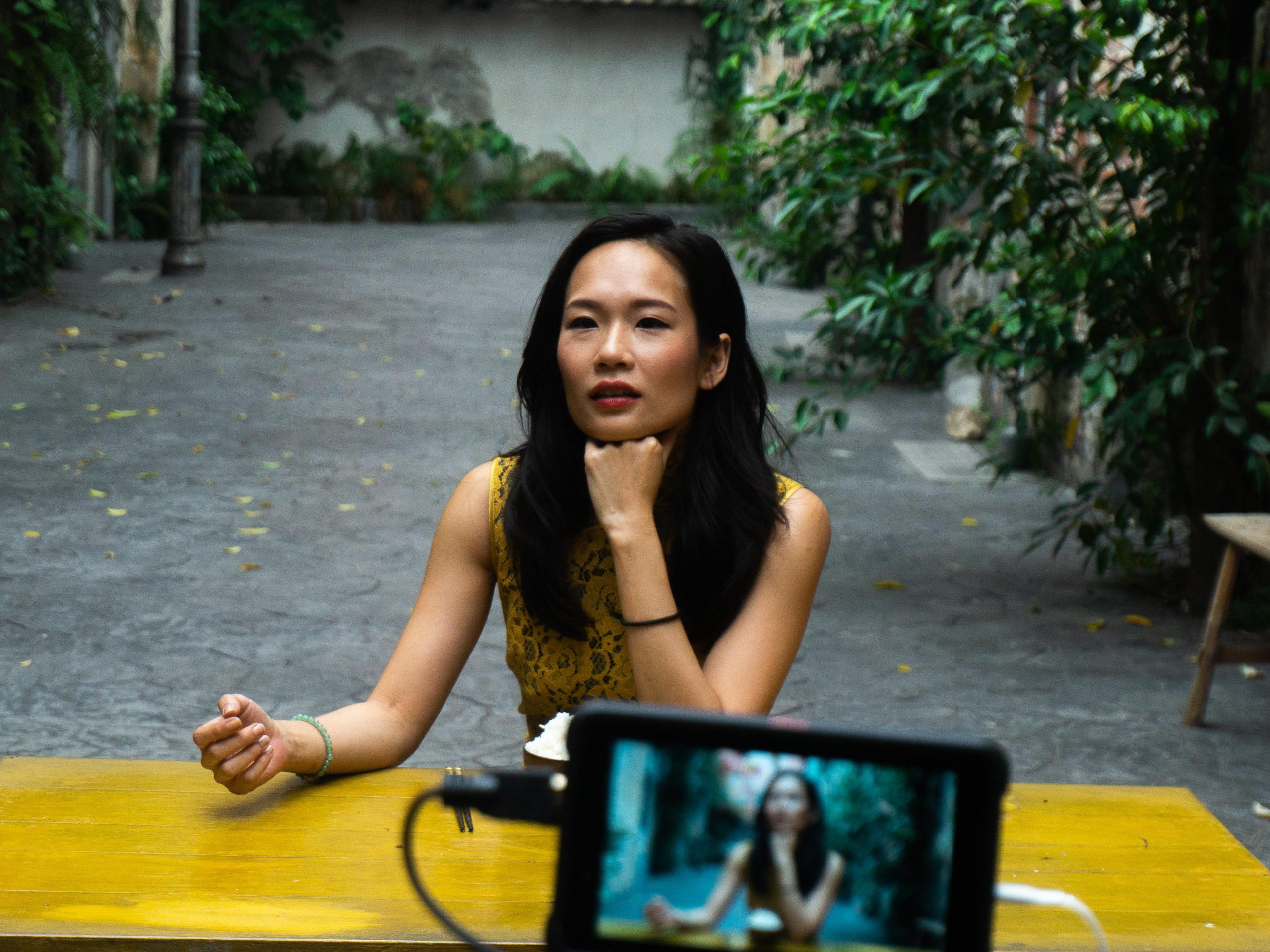 Amanda Ang sebagai Connie, memandang jauh, skrin kamera kelihatan di latar hadapan.